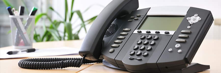A picture of a traditional, black desk phone used for IT services in Red Deer, Canada. The debate for Hardphones vs Softphones.